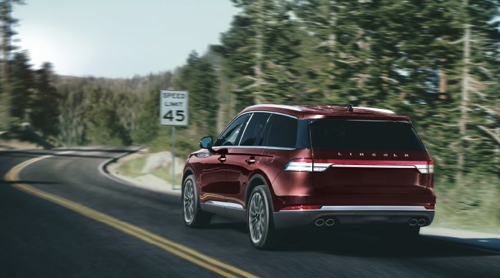 A 2024 Lincoln Aviator® SUV is being driven on a winding mountain road | Lidtke Lincoln in Beaver Dam WI