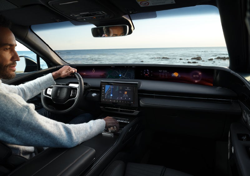 A driver of a parked 2024 Lincoln Nautilus® SUV takes a relaxing moment at a seaside overlook while inside his Nautilus. | Lidtke Lincoln in Beaver Dam WI